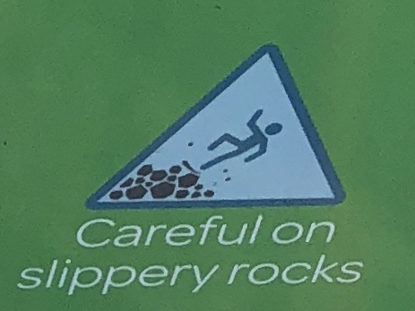 Image of person slipping on rocks with the caption "Careful on Slippery Rocks."