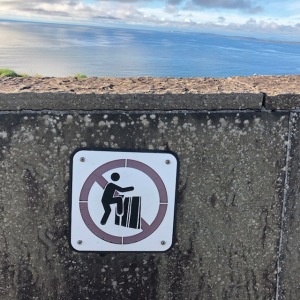 Image of a sign asking people not to climb over a wall at the Cliffs of Moher