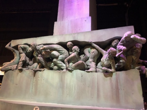 Image of sculpture of muggle being crushed.